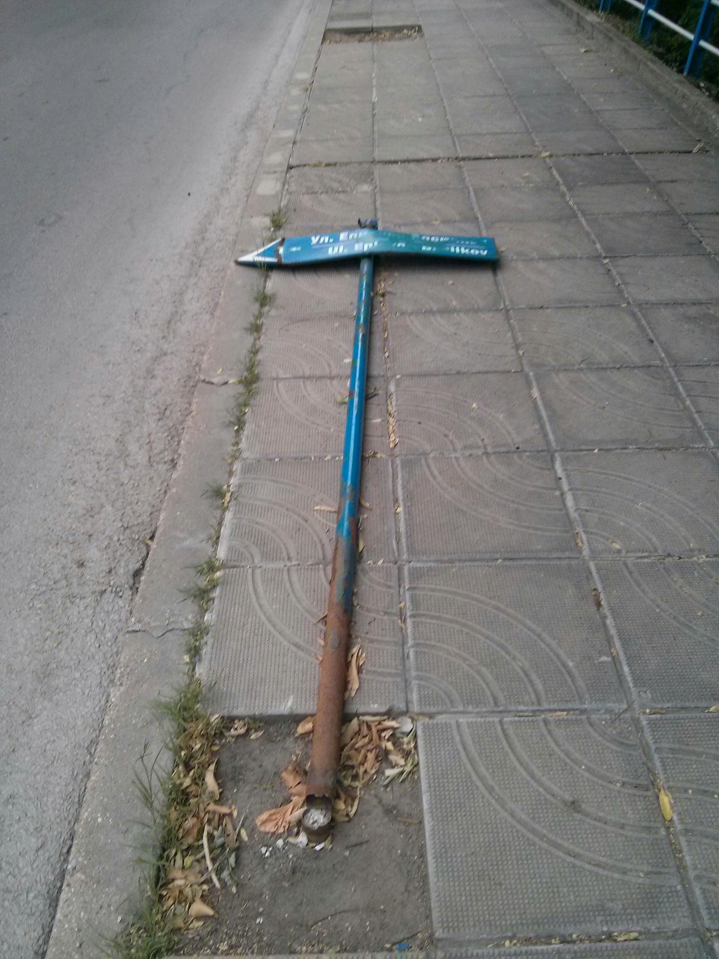 Табелата, която оказва името на улицата вляво, е съборена. 